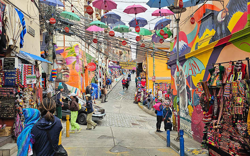 Hexenmarkt mit Souvenirgeschäften, Streetart und aufgespannten, bunten Regenschirmen