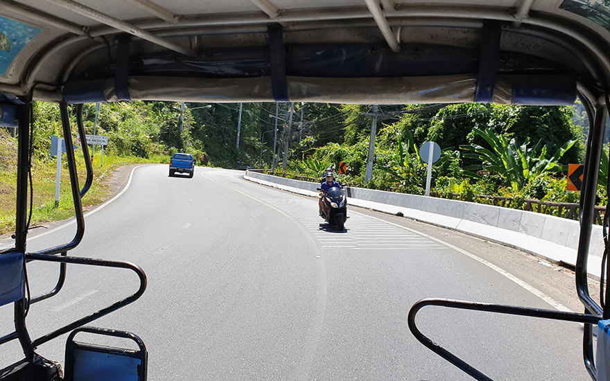Khao Laks Hauptstraße, der Highway Nr. 4, mit Rollerfahrern und Pick-up