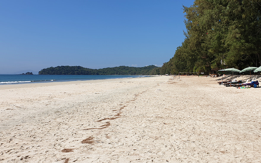 Ao Yai (Long Beach) auf Koh Phayam – langer, heller Sandstrand mit Bäumen am Ufer