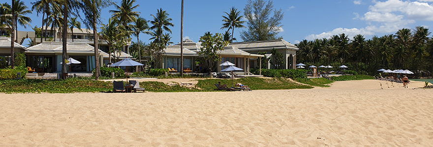 Beach-Bungalows eines Resorts am ruhigen Khuk Khak Beach in Khao Lak mit blauen Sonnenschirmen