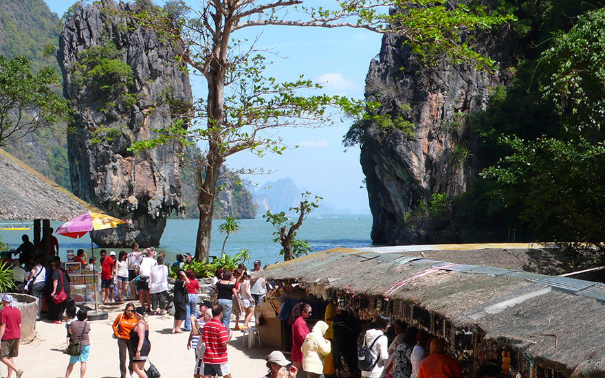 Souvenirstände und Touristen auf Khao Phing Kan mit James-Bond-Felsen im Hintergrund