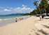 Coconut Beach in Khao Lak mit hellem Sand, türkisfarbenem Wasser, Spaziergängern und weißen Sonnenschirmen