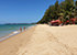 Khuk Khak Beach in Khao Lak mit goldgelbem Sand, türkisfarbenem Wasser und roten Sonnenschirmen