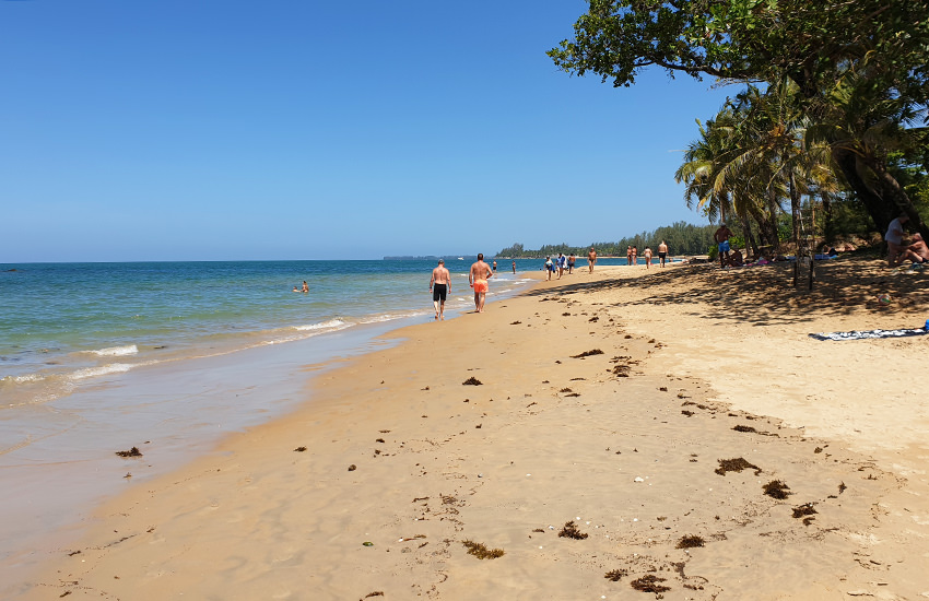 Nang Thong Beach in Khao Lak mit Palmen, Kasuarinen und Spaziergängern