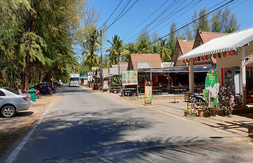 Asphaltierte, schmale Straße nahe Khuk Khak Beach mit Restaurants und Geschäften