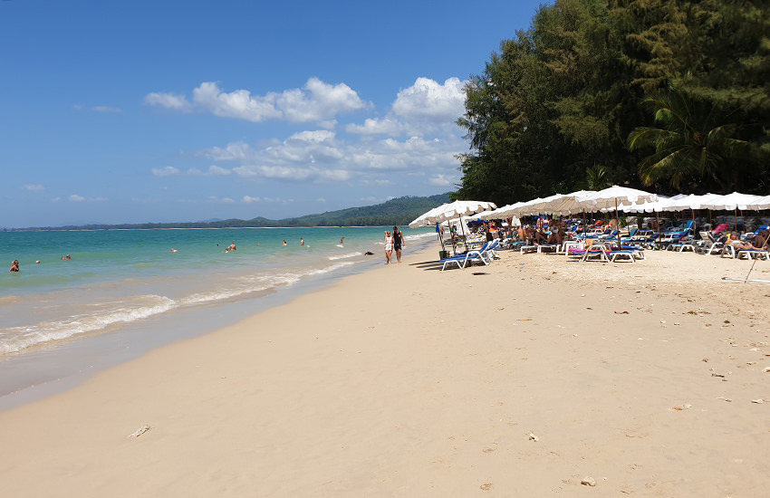 White Sand Beach in Khao Lak mit weißem Sand, türkisfarbenem Meer, weißen Sonnenschirmen und Strandliegen