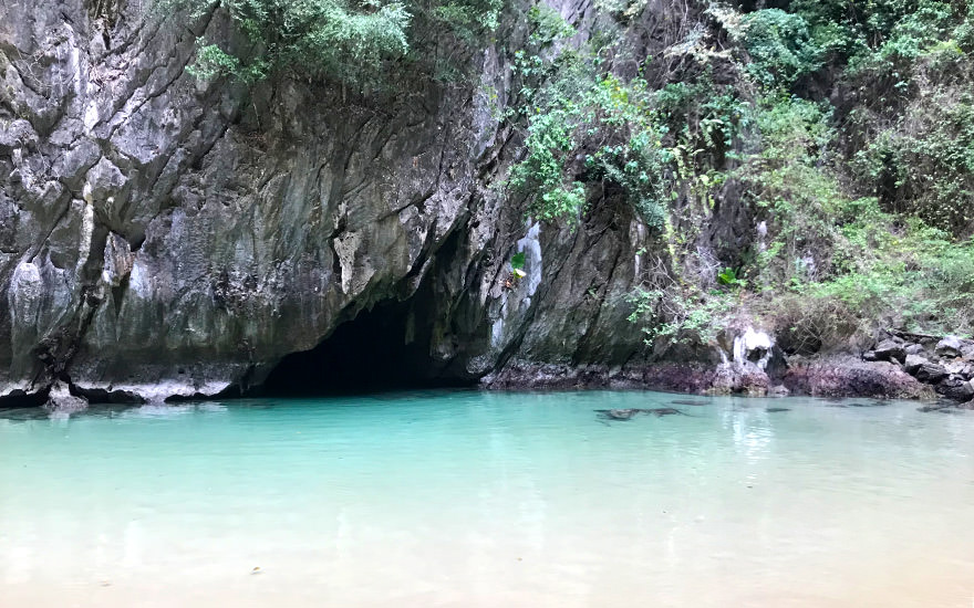 Eingang zur Emerald Cave auf Koh Mook mit türkisfarbener Lagune und kleinem Strand