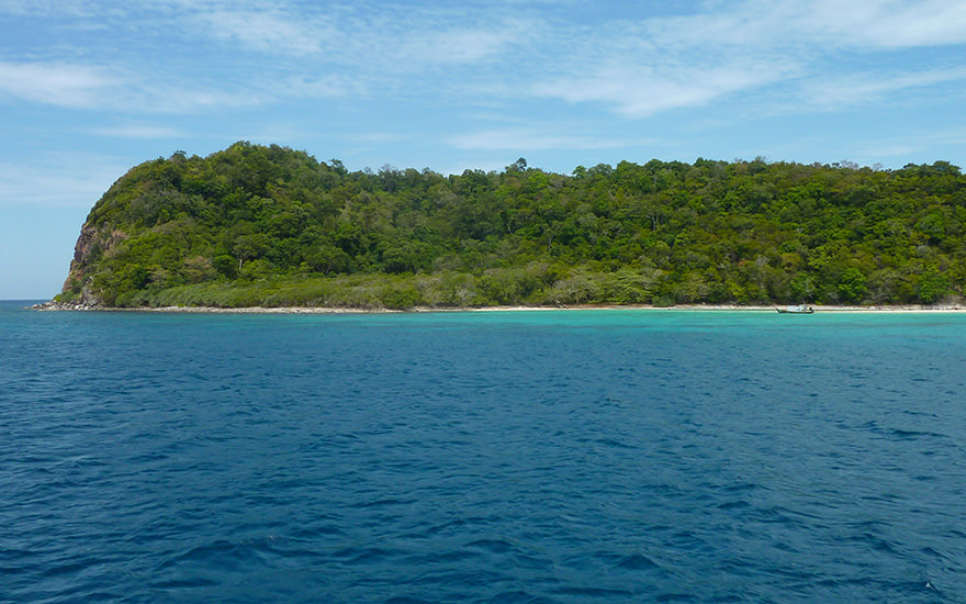Die bewaldete Insel Koh Rok Nok im Mu Ko Lanta Marine-Nationalpark mit blau-türkisfarbenem Meer