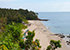 Blick von oben auf den Nui Beach auf Koh Lanta mit Palmen, vereinzelten Felsen und Menschen
