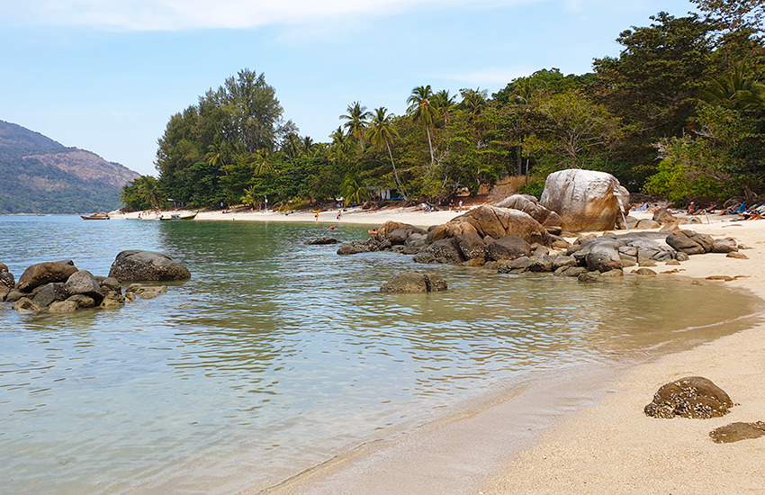 Westliches Ende des Sunset Beach auf Koh Lipe mit Felsen im Wasser