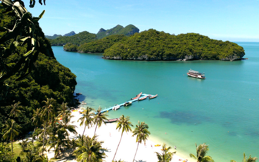 Weißer Sandstrand mit Booten und bewaldete Kalksteininseln im Ang-Thong-Nationalpark