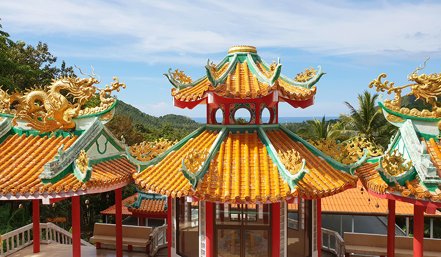 Orangefarbenes Dach des chinesischen Tempels auf Koh Phangan mit goldenen Drachen