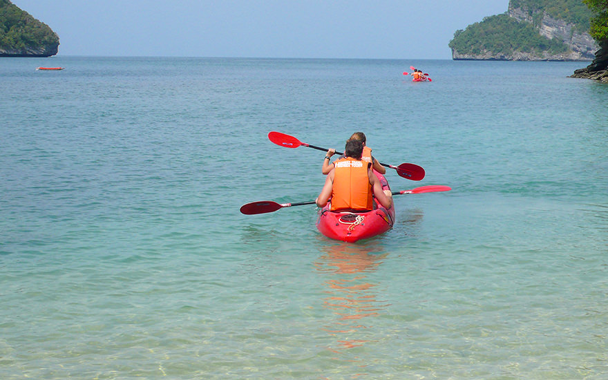 Rotes Kajak mit zwei Paddlern im türkisfarbenem Wasser