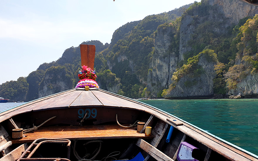 Spitze eines Longtailboots mit den Kalksteinfelsen von Koh Phi Phi Don im Hintergrund