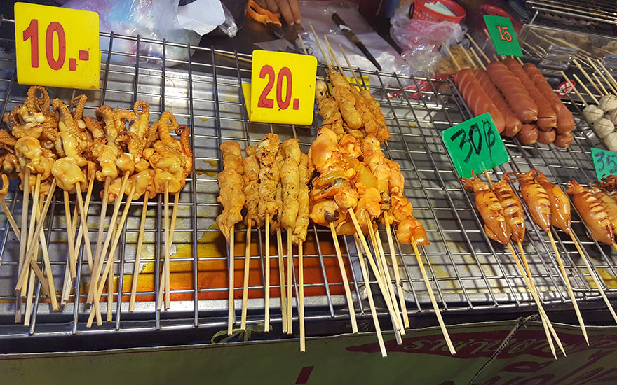 Satée-Spieße mit Preisschildern auf einem Rost