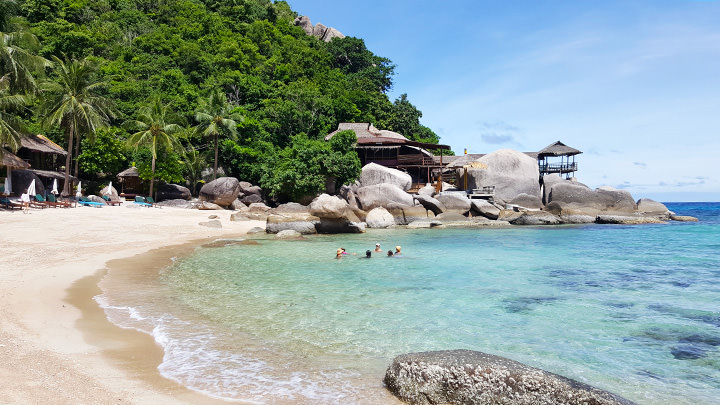 Jansom Bay auf Koh Tao bei sonnigem Wetter mit klarem türkisfarbenem Wasser und ruhigem Meer