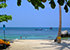 Mae Haad Beach auf Koh Tao mit gelbem Kajak und Palmen am Strand, dahinter türkis-blaues Meer mit Badenden, Felsen und Booten