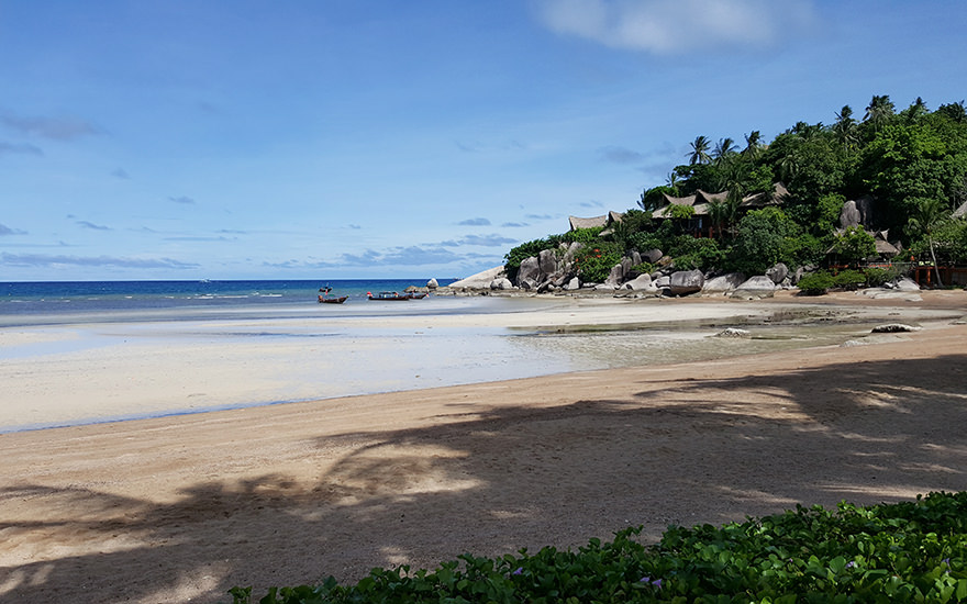 Sairee Beach auf Koh Tao – nördliches Strandende bei Ebbe mit bewalderter Klippe und Bungalows
