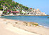 Tanote Bay auf Koh Tao mit gelblichem Sandstrand, blauem Meer und bewaldeter Klippe mit Bungalows