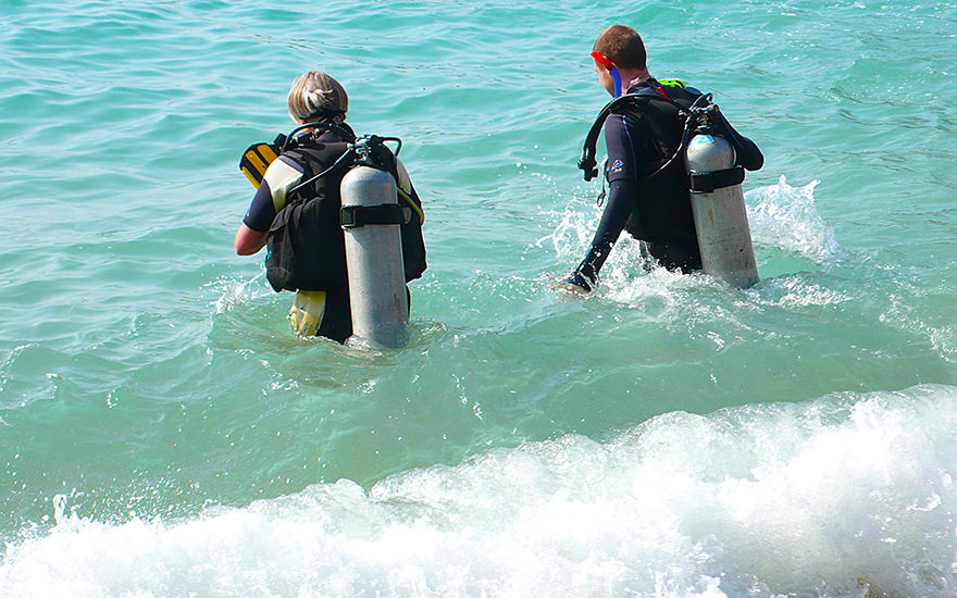 Zwei Taucher im Wasser laufend an der Tanote Bay