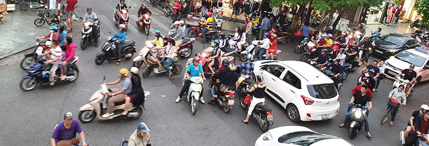 Mopeds und Autos an einer Straßenkreuzung in Hanoi